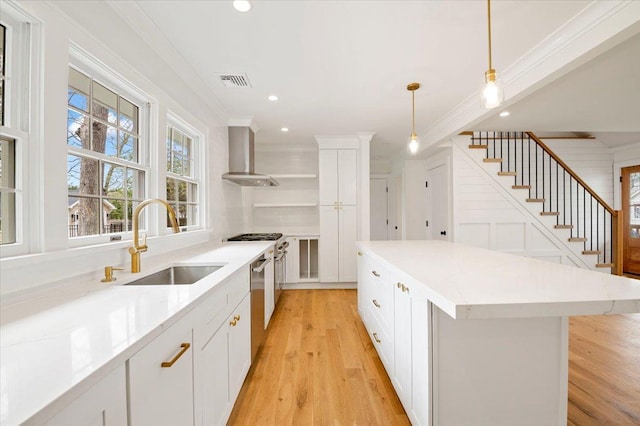1000 Washington Dr, Centerport, NY 11721 - kitchen featuring wall chimney exhaust hood, open shelves, crown molding, a kitchen island, and dishwasher