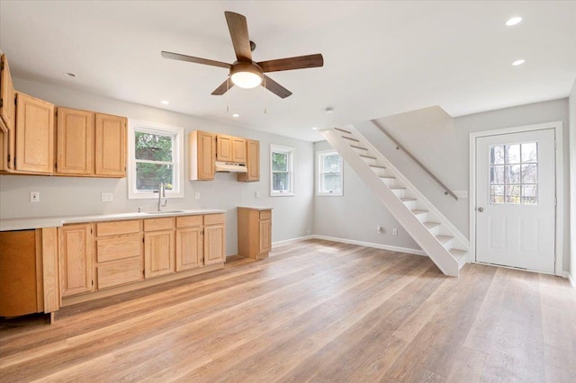 1000 Washington Dr, Centerport, NY 11721 - kitchen with under cabinet range hood, light brown cabinetry, light wood finished floors, healthy amount of natural light, and recessed lighting