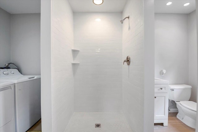 1000 Washington Dr, Centerport, NY 11721 - bathroom featuring a tile shower, washing machine and dryer, vanity, recessed lighting, and wood finished floors
