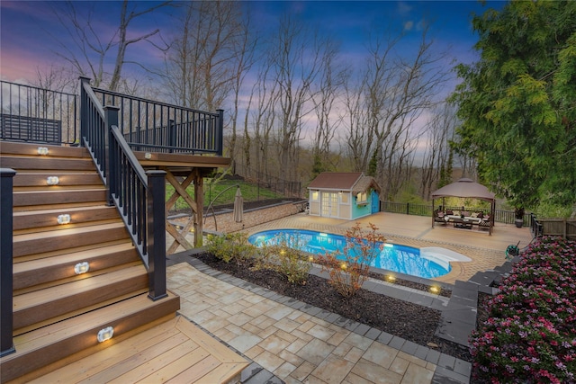 view of swimming pool with an outdoor structure, a gazebo, fence, and a deck