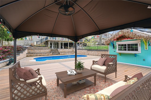 outdoor pool with a gazebo, an outdoor hangout area, fence, and a deck