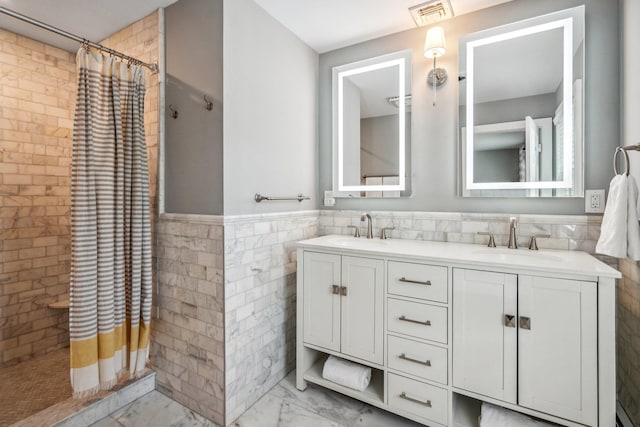 bathroom with a tile shower, visible vents, marble finish floor, and a sink