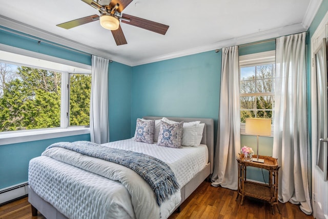 bedroom featuring a baseboard heating unit, wood finished floors, and ornamental molding