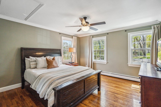 bedroom featuring a baseboard heating unit, wood finished floors, ornamental molding, and attic access