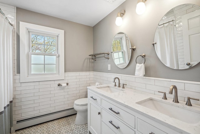 bathroom featuring a baseboard radiator, tile walls, toilet, and a sink
