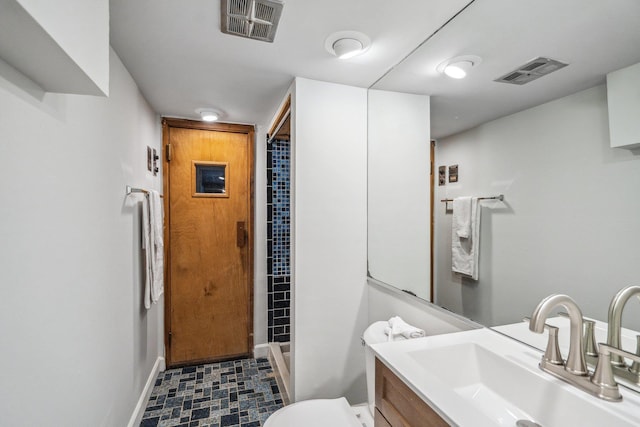bathroom featuring visible vents, vanity, baseboards, and a walk in shower
