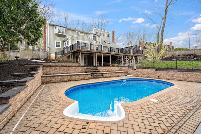 view of pool with a wooden deck, a fenced in pool, stairway, and fence