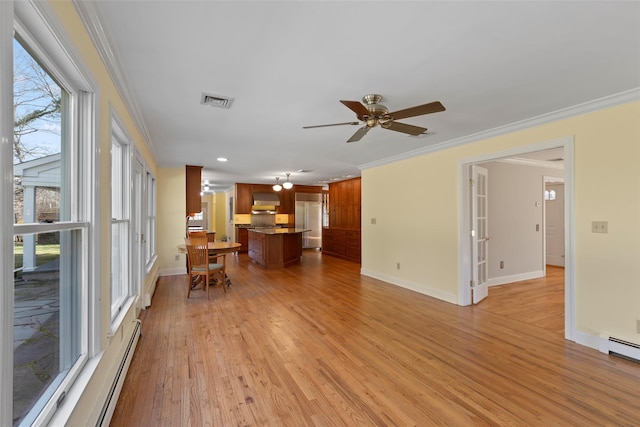living room featuring baseboard heating, baseboards, and crown molding