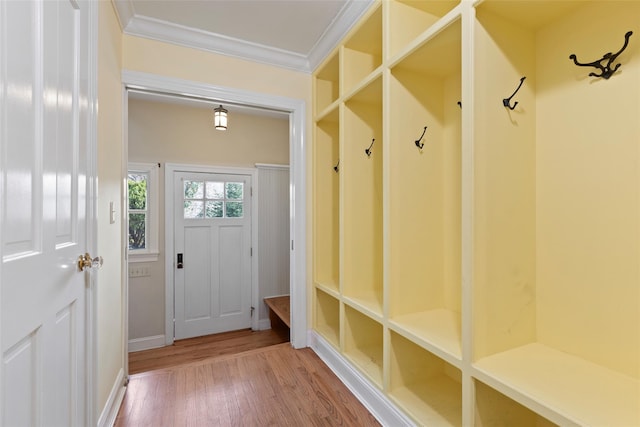 mudroom with baseboards, crown molding, and wood finished floors