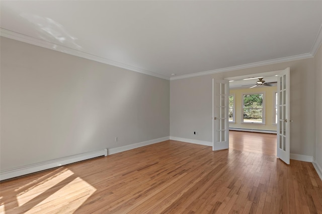 empty room with light wood-style floors, crown molding, baseboards, and french doors