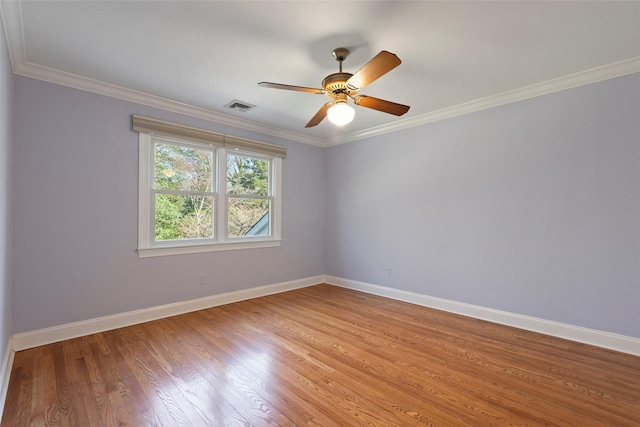 empty room with baseboards, crown molding, visible vents, and light wood-type flooring