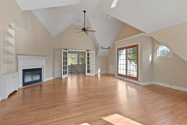 unfurnished living room with a fireplace, light wood finished floors, a ceiling fan, and baseboards