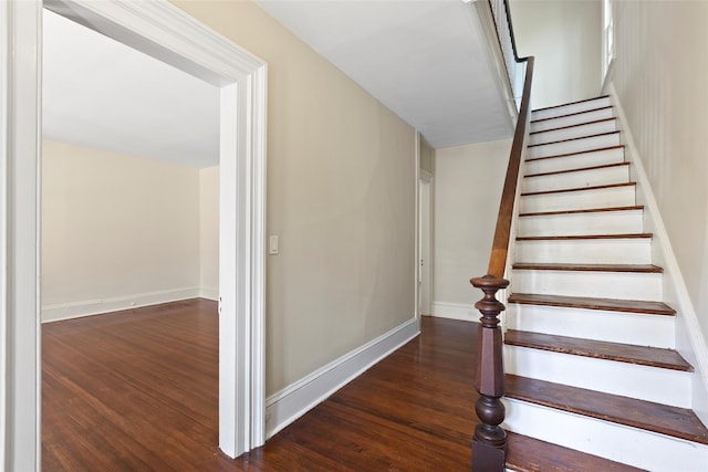 staircase with baseboards and wood finished floors