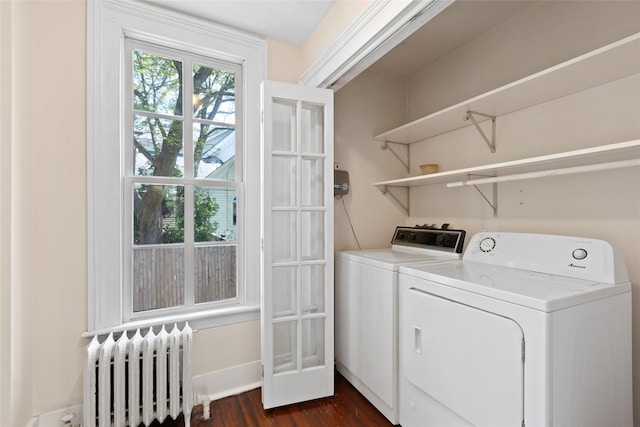 laundry area featuring dark wood-style floors, baseboards, radiator, separate washer and dryer, and laundry area