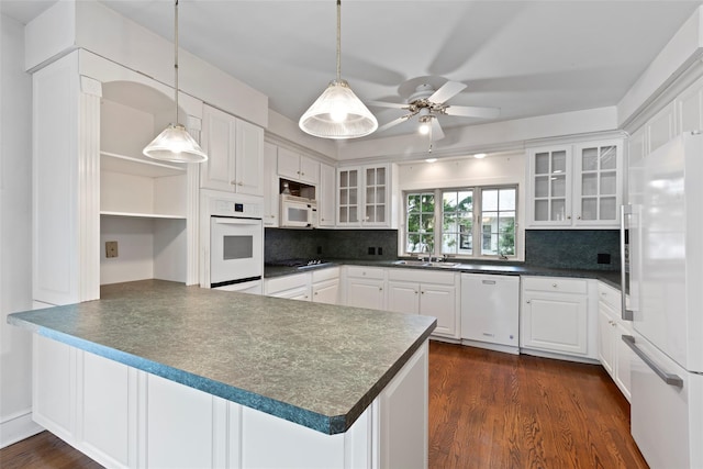 kitchen featuring open shelves, dark countertops, white appliances, a peninsula, and backsplash