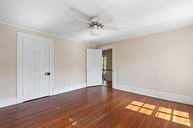 spare room with wood finished floors, a ceiling fan, crown molding, and baseboards