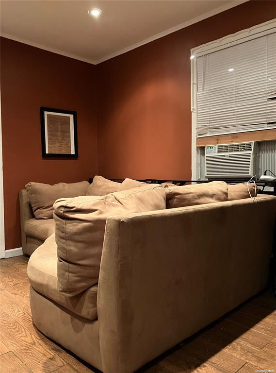 19 Tatterson St, Roslyn, NY 11576 - home theater room featuring crown molding, cooling unit, light wood-style flooring, baseboards, and recessed lighting