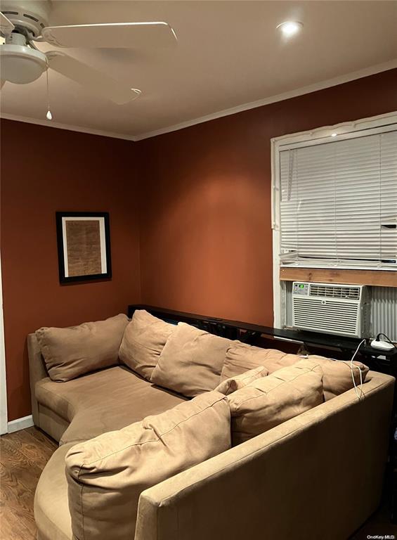 19 Tatterson St, Roslyn, NY 11576 - living area featuring wood finished floors, a ceiling fan, cooling unit, and ornamental molding