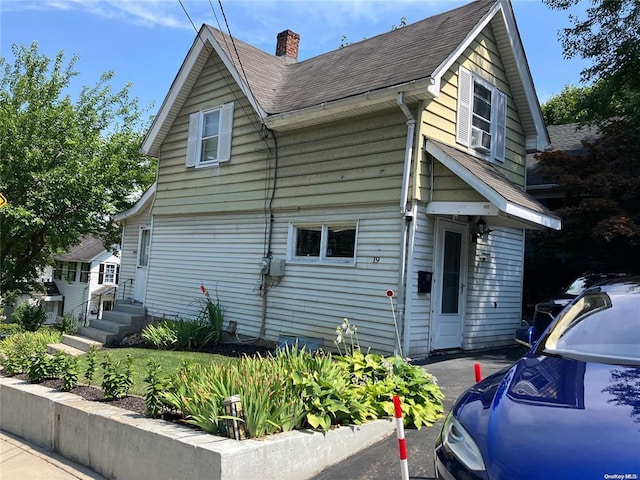 19 Tatterson St, Roslyn, NY 11576 - view of side of home featuring a chimney, entry steps, and a shingled roof