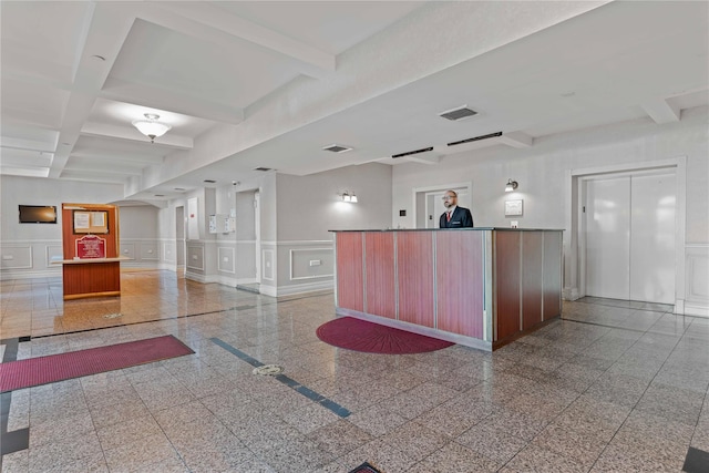 reception area featuring a decorative wall, beamed ceiling, coffered ceiling, and wainscoting