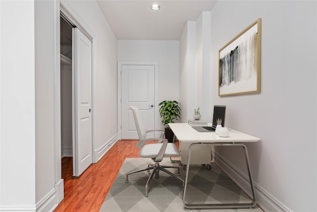 office space with light wood-type flooring, recessed lighting, and baseboards