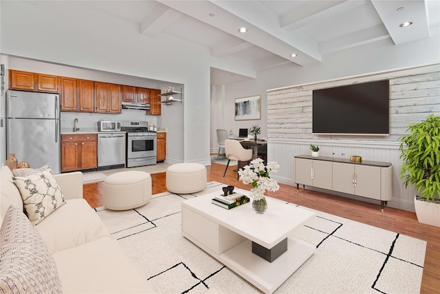 living room with light wood-style floors, recessed lighting, beam ceiling, and baseboards
