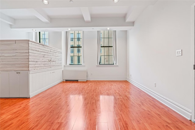 unfurnished room with beamed ceiling, wood finished floors, radiator, recessed lighting, and a wainscoted wall