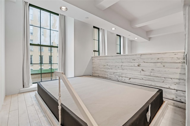 unfurnished bedroom with multiple windows, beamed ceiling, and recessed lighting