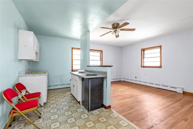 420 Old Country Rd, Melville, NY 11747 - kitchen with white cabinets, a ceiling fan, light countertops, and a baseboard radiator