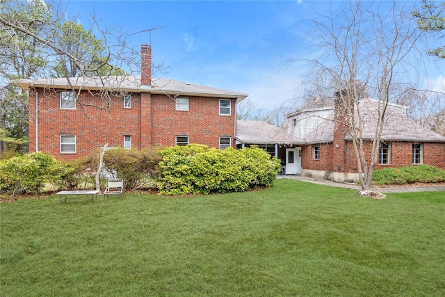 420 Old Country Rd, Melville, NY 11747 - rear view of house with a lawn, a chimney, and brick siding