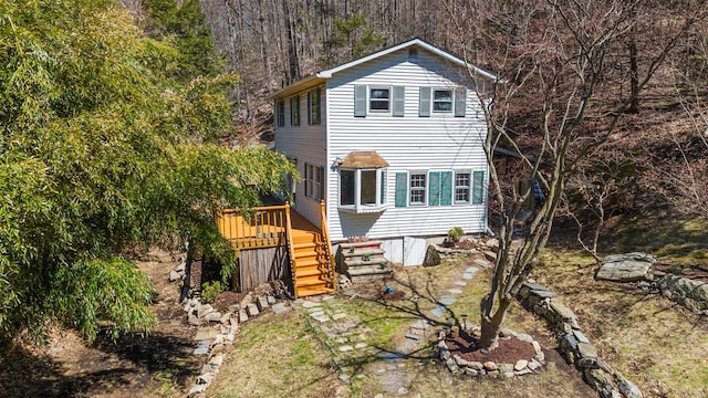 exterior space with a wooden deck, stairway, and a wooded view
