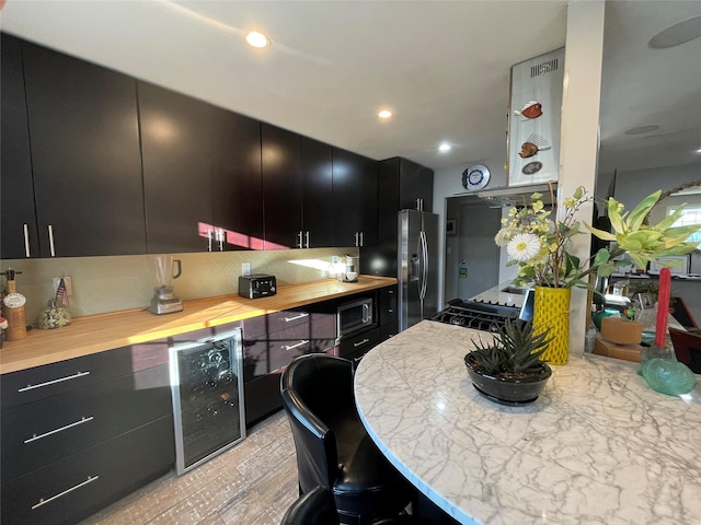 kitchen with backsplash, stainless steel refrigerator with ice dispenser, built in microwave, wine cooler, and dark cabinets