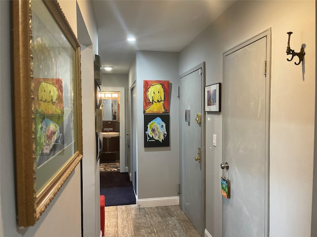 hall with recessed lighting, baseboards, and wood finished floors