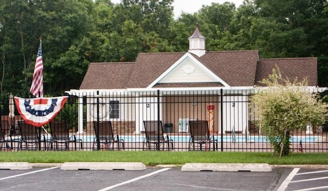 view of gate featuring fence and a community pool