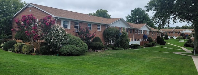 rear view of property featuring brick siding and a yard