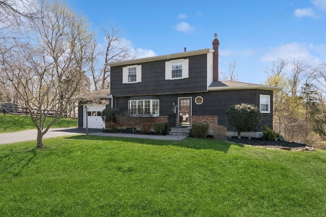colonial home with a front lawn, a garage, a chimney, and concrete driveway