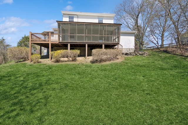 back of property featuring a sunroom, a yard, and a deck