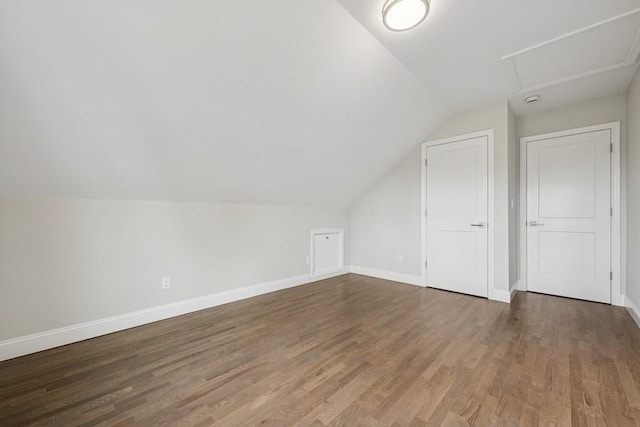 bonus room with vaulted ceiling, wood finished floors, and baseboards