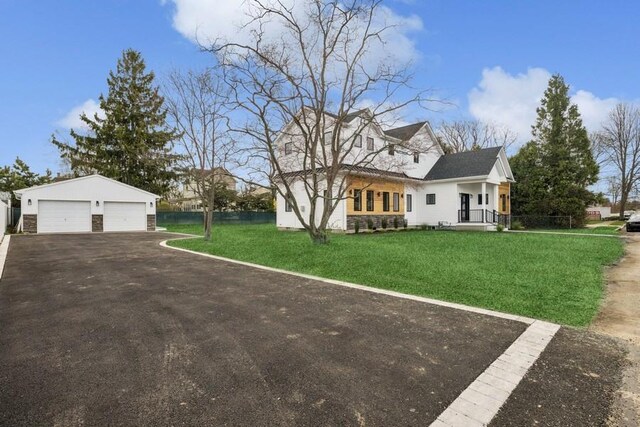 148 S 5th St, Lindenhurst, NY 11757 - view of front of property with a front lawn, stone siding, an outbuilding, and a detached garage