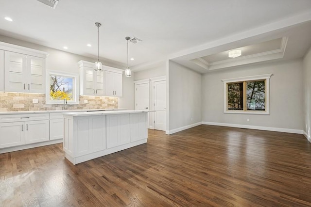 148 S 5th St, Lindenhurst, NY 11757 - kitchen with decorative backsplash, a kitchen island, light countertops, white cabinetry, and glass insert cabinets