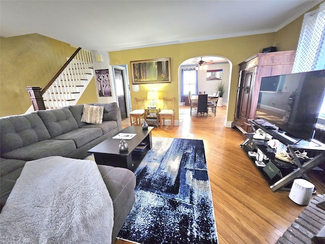 132-29 Brookville Blvd, Rosedale, NY 11422 - living area featuring stairs, light wood-style floors, arched walkways, and ceiling fan