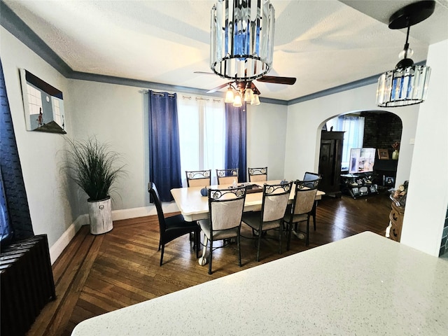 132-29 Brookville Blvd, Rosedale, NY 11422 - dining room with radiator, arched walkways, wood-type flooring, baseboards, and a ceiling fan