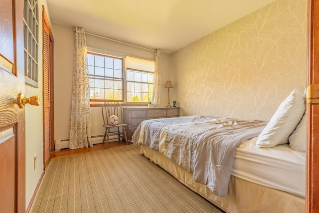 bedroom featuring baseboard heating, baseboards, and carpet flooring