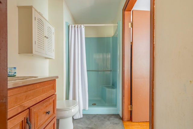 full bathroom featuring a stall shower, toilet, and vanity