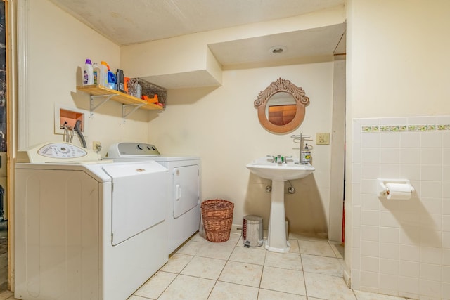 laundry area featuring washer and clothes dryer and light tile patterned floors