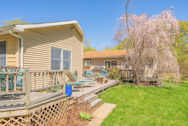 back of property featuring a deck and a lawn