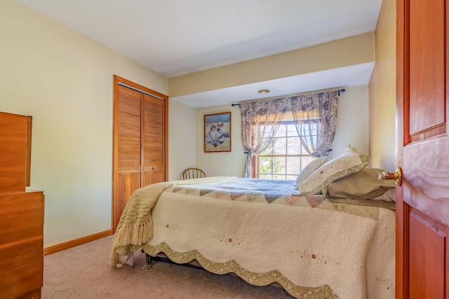 carpeted bedroom featuring a closet and baseboards