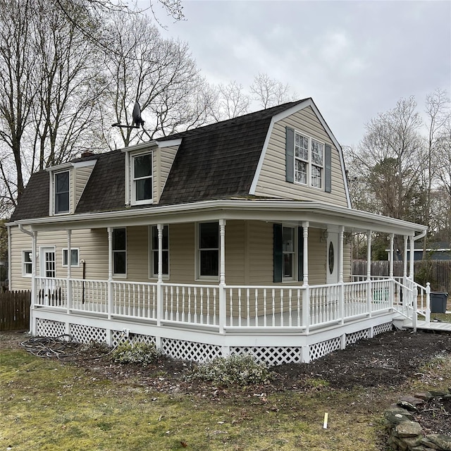 view of front of house featuring roof with shingles, a porch, and a gambrel roof