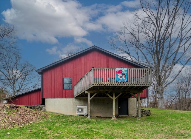 back of property with a yard, ac unit, and a deck