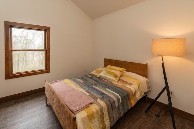 bedroom with baseboards, vaulted ceiling, and wood finished floors